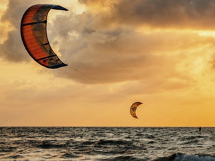 person surfing on sea during sunset